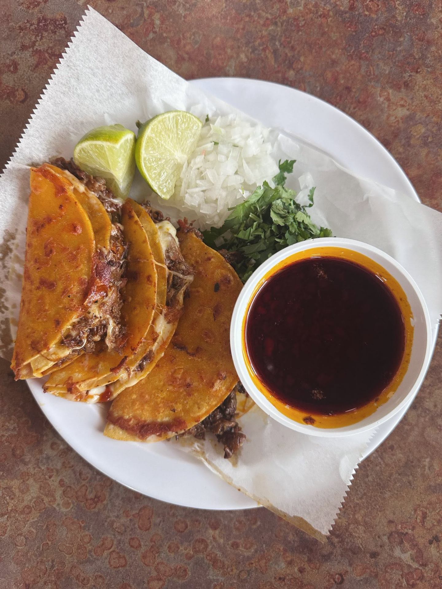 Steaming birria de res with rich consommé for dipping.