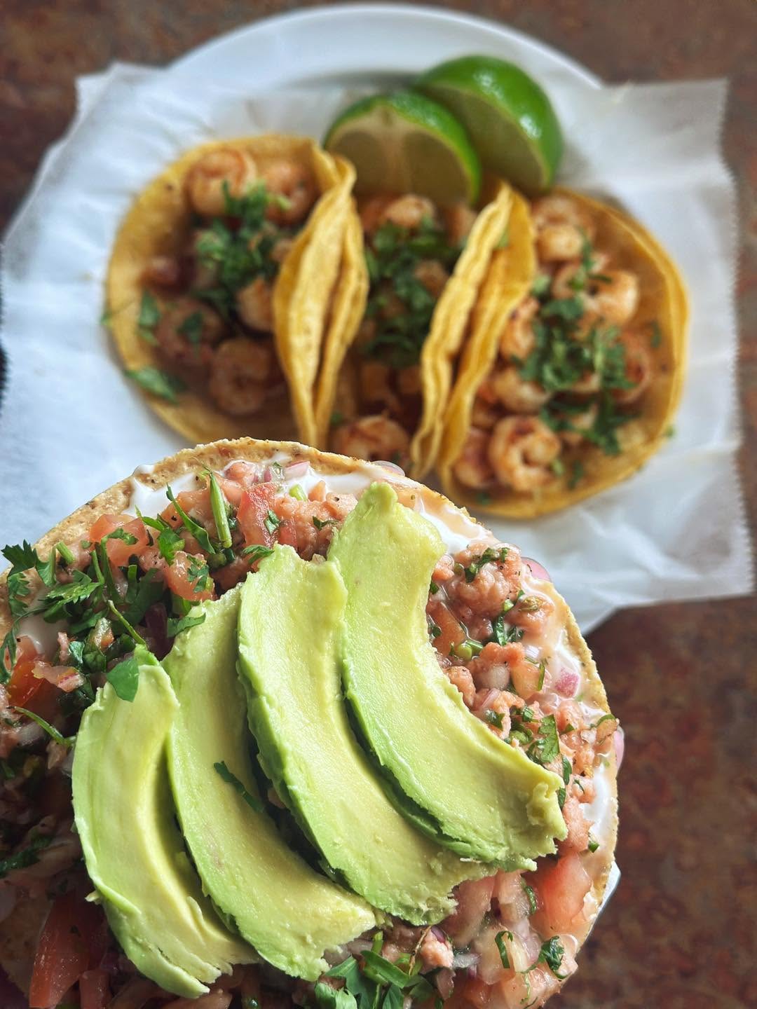 Fresh shrimp ceviche piled with lime, tomato, onion, and cilantro in a clear bowl.